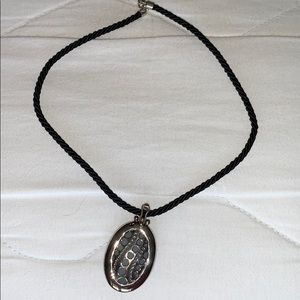 Silver pendant on black cord